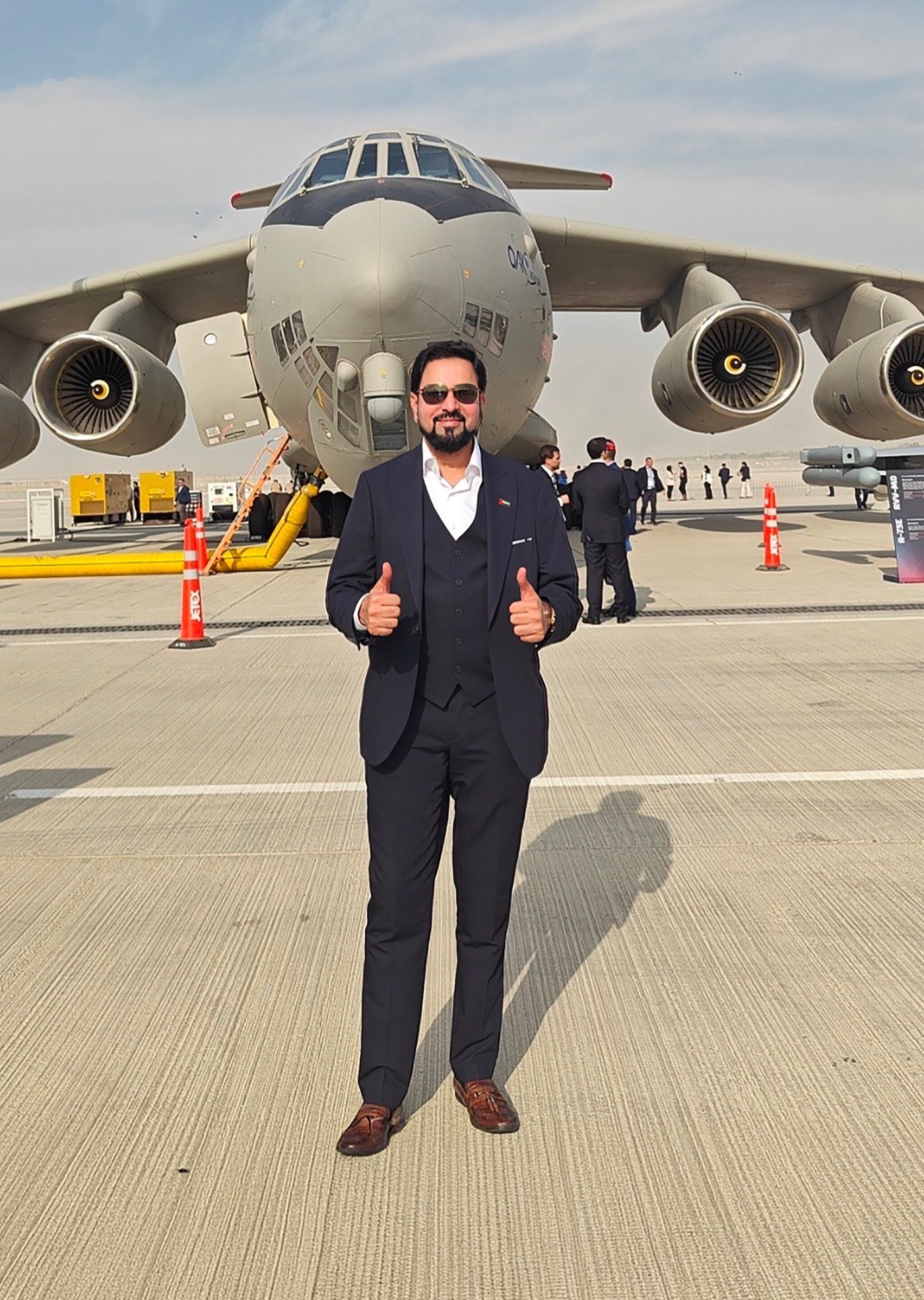 Mohamed Sulthan on the apron in front of a four-engine transport aircraft.